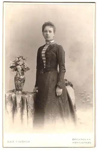 Fotografie Max Fischer, Dresden, Moritzstrasse 8b, Bildhübsche Frau im Kleid steht neben Blumenvase