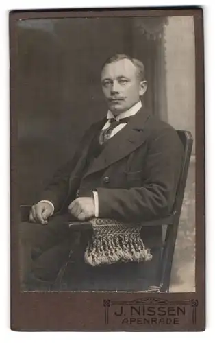 Fotografie J. Nissen, Apenrade, Herr in bürgerlicher Kleidung sitzt in einem Stuhl