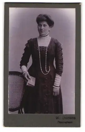 Fotografie W. Doracn, Ort unbekannt, Gutbürgerliche Frau mit Hochsteckfrisur und Bibel