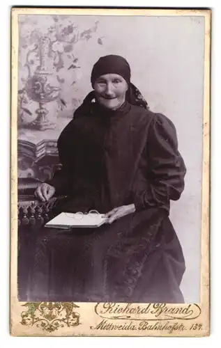 Fotografie Richard Brand, Mittweida, Bahnhofstr. 137, Ältere Frau in schwarzem Kleid und Buch auf dem Schoss