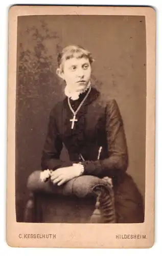 Fotografie C. Kesselhuth, Hildesheim, Junge Frau in schwarzem Kleid und Kreuzkette