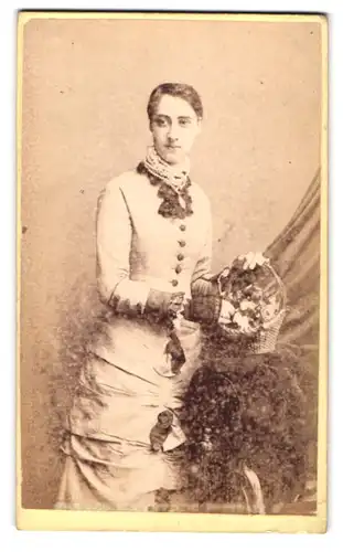 Fotografie The London Artistic Portrait Co., London, 108 Oxford St., Junge hübsche Frau in weissem Kleid trägt Körbchen