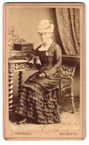 Fotografie J. Hartmann, Bayreuth, Schwarze Allee, Junge Frau in elegantem Kleid und extravagantem Hut