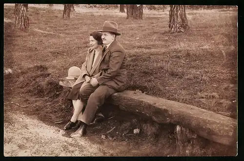 Fotografie Paar beim Waldspaziergang auf uriger Holzbank sitzend