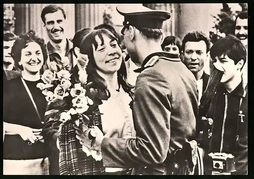 Archiv-Fotografie unbekannter Fotograf, Ansicht Berlin, Französische Jugendliche überreichen Blumen an NVA Grenzsoldat