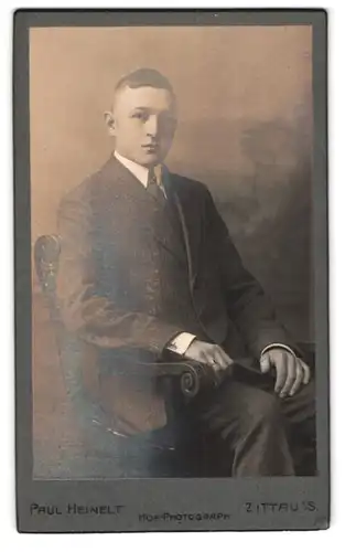 Fotografie Paul Heinelt, Zittau i. S., Bautzenerstr. 18, Junger Mann im Anzug sitzt auf Stuhl