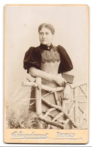 Fotografie E. Engelmeyer, Berlin, Gr. Frankfurterstrasse 89, Dame im Kleid mit Puffärmeln und Buch in der Hand