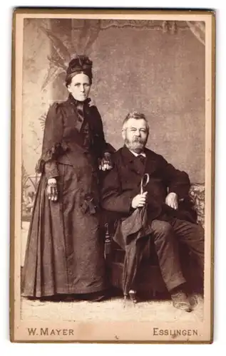 Fotografie W. Mayer, Esslingen, Mann im Sessel, Ehefrau steht daneben