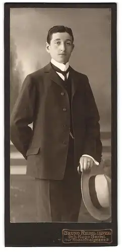 Fotografie Bruno Riedel, Leipzig, Rosenthalgasse 9, Junger eleganter Mann im Anzug mit Sommerhut in der Hand