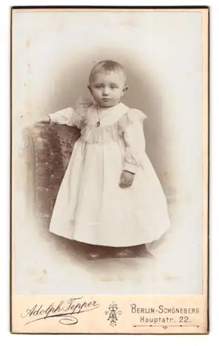 Fotografie Adolph Tepper, Berlin-Schöneberg, Hauptstr. 22, Portrait Baby in weissem Kleid mit Halskette