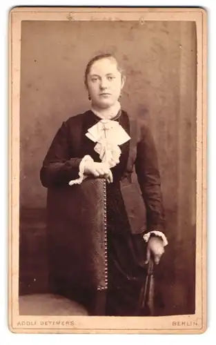 Fotografie Adolf Dettmers, Berlin, Prinzen-Str. 86, Portrait junge Dame in schwarzem Kleid beim Stuhl