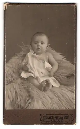 Fotografie Atelier Neuwirth, Gotha, Erfurterstr. 15, Portrait Baby in weissem Kleid auf Fell