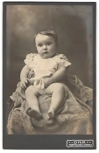 Fotografie Ohm, Nordhausen, Weberstr. 2, Kleinkind in weissem Kleid auf Stuhl sitzend