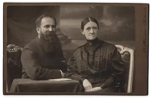 Fotografie J. Mürnseer, Karlsruhe, Küppurrerstr. 16, Eleganter Mann mit Vollbart und Gattin in schönem Kleid