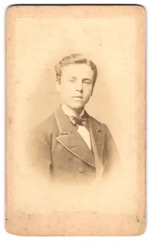 Fotografie Emil Rolla, Kyritz, Portrait eines elegant gekleideten junge Mannes in Fliege und Jackett