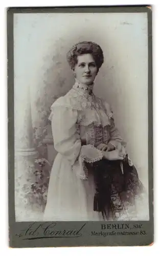 Fotografie Ad. Conrad, Berlin, Markgrafenstr. 83, Portrait hübsche junge Frau in gerüschtem Kleid