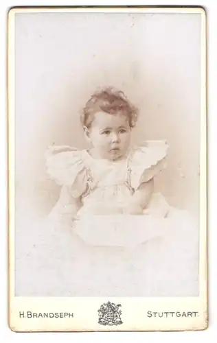 Fotografie H. Brandseph, Stuttgart, Marienstr. 36, Portrait kleines Mädchen mit lockigem Haar im weissen Rüschenkleidchen