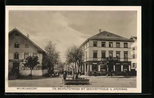 AK Wilhelmsdorf, Die Institutstrasse mit Geschäftshaus und Apotheke