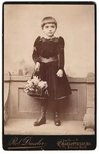Fotografie R. Dressler, Berlin-Charlottenburg, Schloss-Strassee 15, Kind in schwarzem Kleid trägt Blumen
