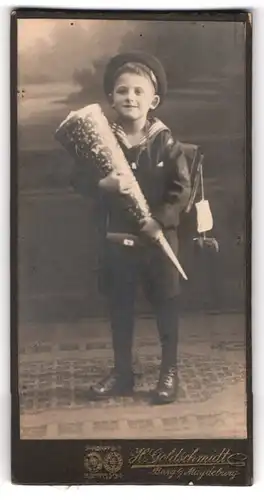 Fotografie H. Goldschmidt, Burg b. M., Portrait Knabe im Matrosenanzug mit Zuckertüte und Schulranzen, erster Schultag