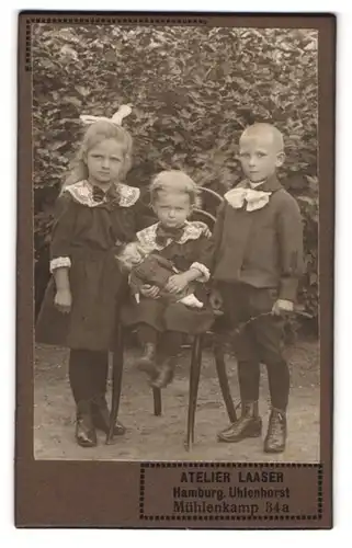Fotografie Atelier Laaser, Hamburg, Mühlenkamp 34, Portrait drei niedliche Kinder mit Puppe im Arm