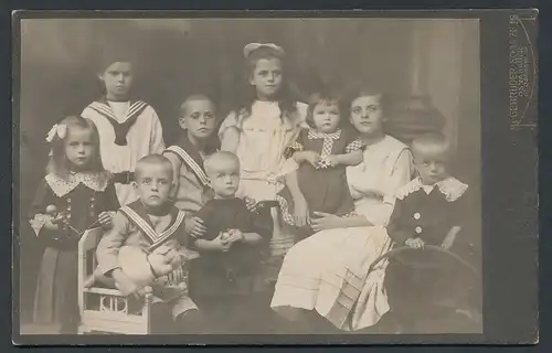 Fotografie Gebr. Schulze, Osnabrück, Grosse-Str. 19, Portrait 9 Kinder in Matrosenanzügen und Kleidern im Atelier