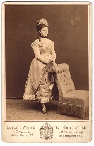 Fotografie Lutze & Witte, Görlitz, Portrait junge Dame im feinen Kleid mit Fächer und Haarschmuck