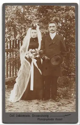 Fotografie Carl Lichtenstein, Braunschweig, Portrait Eheleute im schwarzen Hochzeitskleid und Anzug mit Zylinder