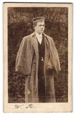 Fotografie Portrait und Ort unbekannt, Portrait junger Student im Mantel mit Tellermütze