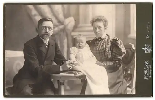 Fotografie E. Hoeffle, Bamberg, Portrait Mutter und Vater mit ihrem Kleinkind im Atelier, Mutterglück