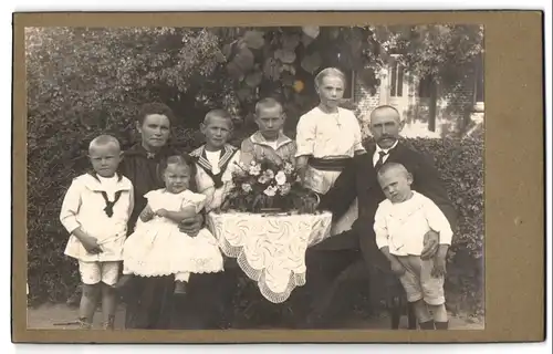 Fotografie unbekannter Fotograf und Ort, Portrait Mutter und Vater mit sechse Kindern im Garten, Mutterglück