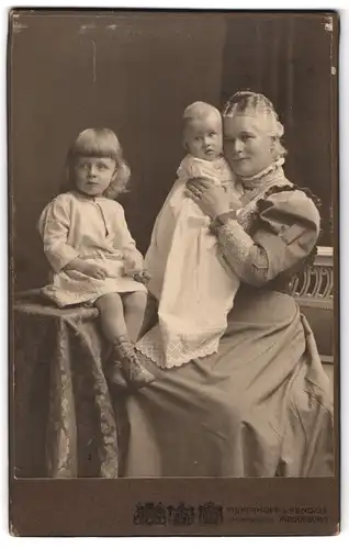 Fotografie Pieperhoff & Fendius, Magdeburg, Portrait stolze Grossmutter mit ihren zwei Kindern im Atelier, Mutterglück