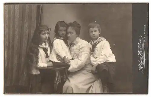 Fotografie Atelier Walther, Kiel, Klinke 26, Mutter Olga mit drei Kindern in Matrosenkleidern im Atelier, Mutterglück