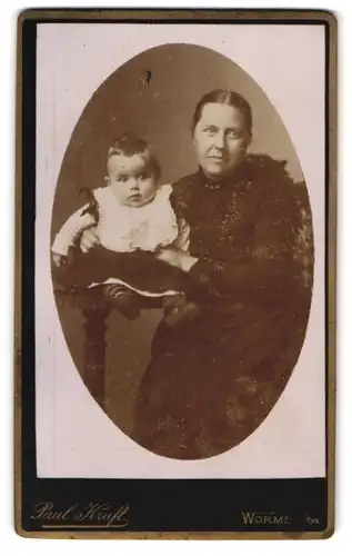Fotografie Paul Kraft, Worms a. Rh., Portrait Mutter im Biedermeierkleid mit ihrem Kinde auf dem Tisch, Mutterglück