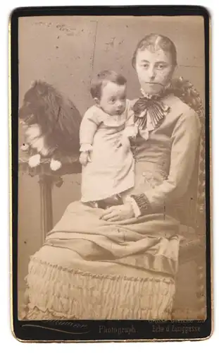 Fotografie unbekannter Fotograf und Ort, Portrait Mutter mit ohrem Kind auf dem Schoss, Hund sitzt auf dem Tisch
