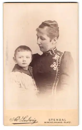 Fotografie Ad. Ludwig, Stendal, Winckelmanns-Platz, Portrait Mutter im engen Kleid mit ihrem Sohn im Arm