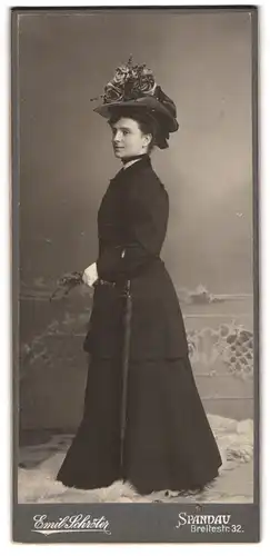 Fotografie Emil Schröter, Berlin-Spandau, Breitestr. 32, Portrait Dame im schwarzen Kleid mit Blumenhut, Regenschirm
