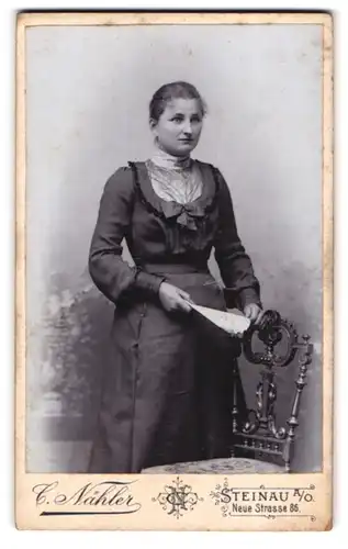 Fotografie C. Nähler, Steinau a. O., Neue Strasse 86, Junge Frau in modischem Kleid an Stuhl gelehnt