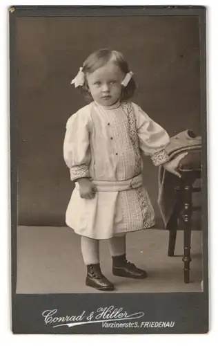 Fotografie Conrad & Hiller, Friedenau, Varzinerstrasse 3, Kleine Mädchen mit Haarschleifen im Kleid 1910