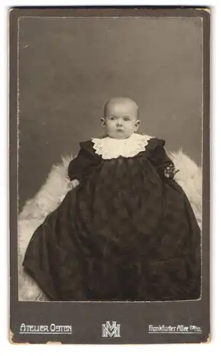 Fotografie Atelier Osten, Berlin, Frankfurter Allee 109-12, Süsses Kleinkind im langen Kleid sitzt auf Fell