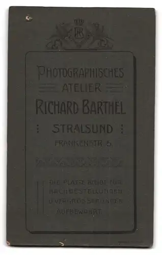 Fotografie Richard Barthel, Stralsund, Frankenstr. 5, Süsses Kleinkind im Kleid sitzt auf Fell
