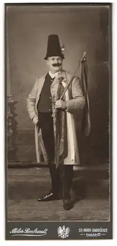 Fotografie Atelier Rembrandt, St. Johann, Bahnhofstr. 67, Portrait Herr im Kostüm mit hohem Hut und Taktstock, Fasching