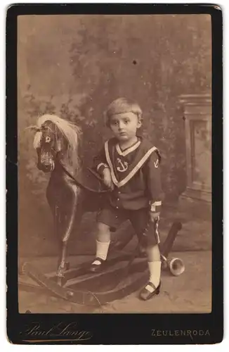 Fotografie Paul Lange, Zeulenroda, Portrait junger Knabe im Matrosenanzug mit grossem Schaukelpferd