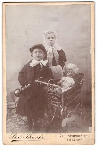 Fotografie Paul Krienke, Christophswalde, zwei Kinder mit grosser Puppe im Puppenwagen und Blechtrompete