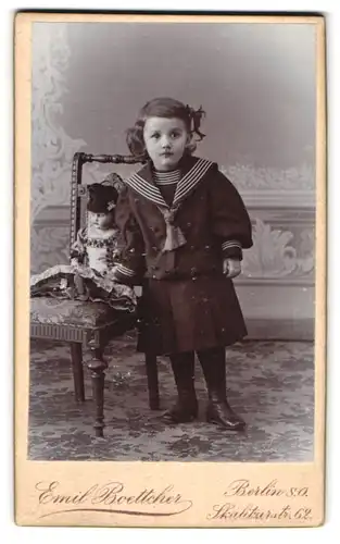 Fotografie Emil Boettcher, Berlin, Portrait süsses Mädchen im Matrosenkleid mit Puppe auf dem Stuhl