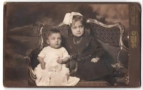 Fotografie William Roth, Berlin, Skalitzerstr. 54, Portrait zwei kleine Kinder mit ihrem Teddybär auf einem Sofa