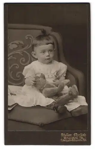 Fotografie Atelier Ehrlich, Dresden, Portrait Kleinkind im Kleidchen mit Teddybär auf dem Schoss