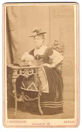 Fotografie A. Menzendorf, Berlin, Louisenstr. 59, Portrait Dame im Samtkleid mit einer Ziether auf dem Tisch