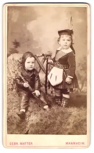 Fotografie Gebr. Matter, Mannheim, Portrait zwei niedliche Kinder in schottischer Tracht und als Froschmann