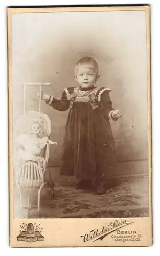 Fotografie Wilhelm Stein, Berlin, Chausseestr. 66, Portrait niedliches Mädchen im Samtkleid mit Puppe im Puppenwagen